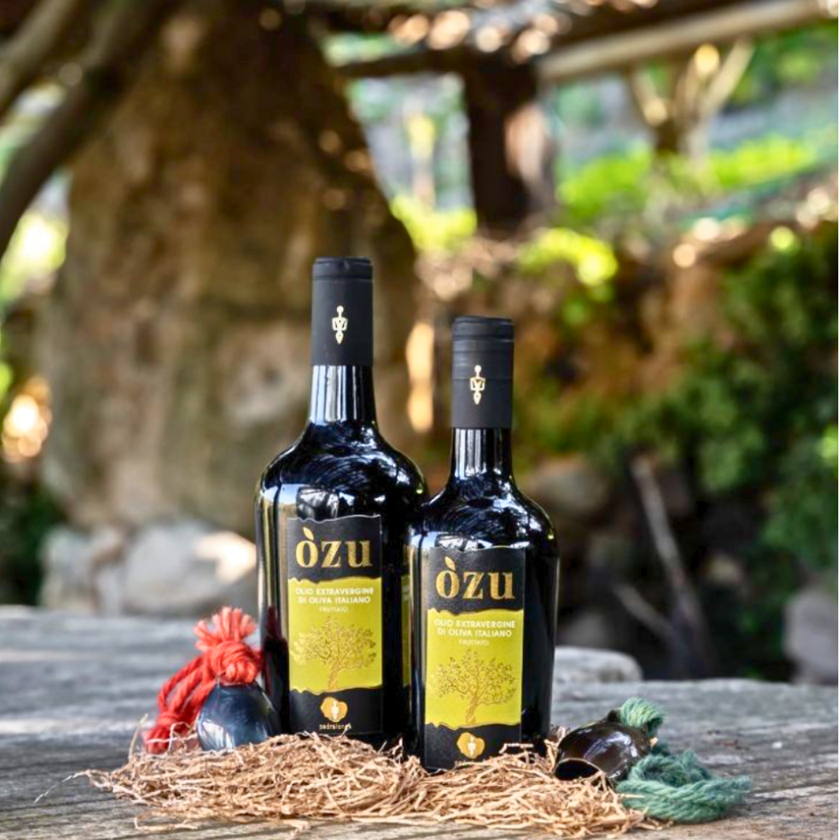 Die Flaschen Olivenöl Òzu von Pedralonga auf einem Holztisch