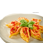 Culurgiones mit einer Tomatensauce auf einem Teller angerichtet. Verziert mit Basilikum.