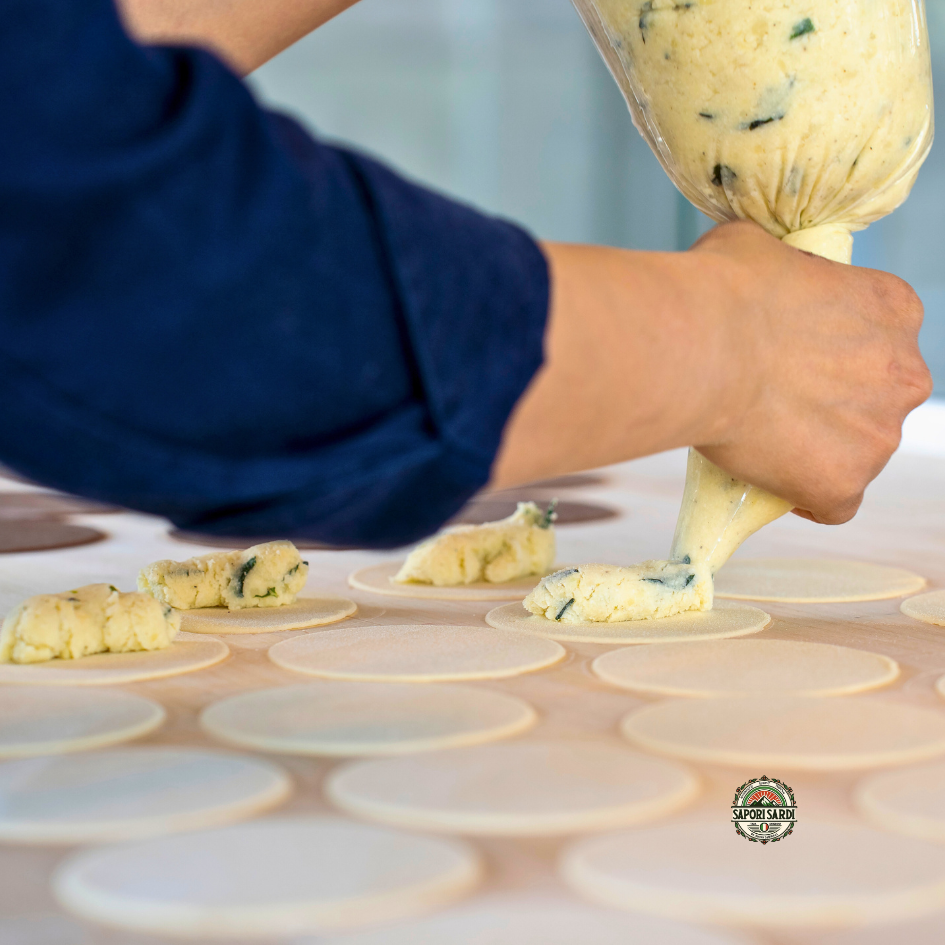 Der Teig für Culurgiones wurde ausgerollt und Kreisförmig ausgeschnitten. Nun wird die Füllung auf den Teig gesetzt bevor er verschlossen wird.