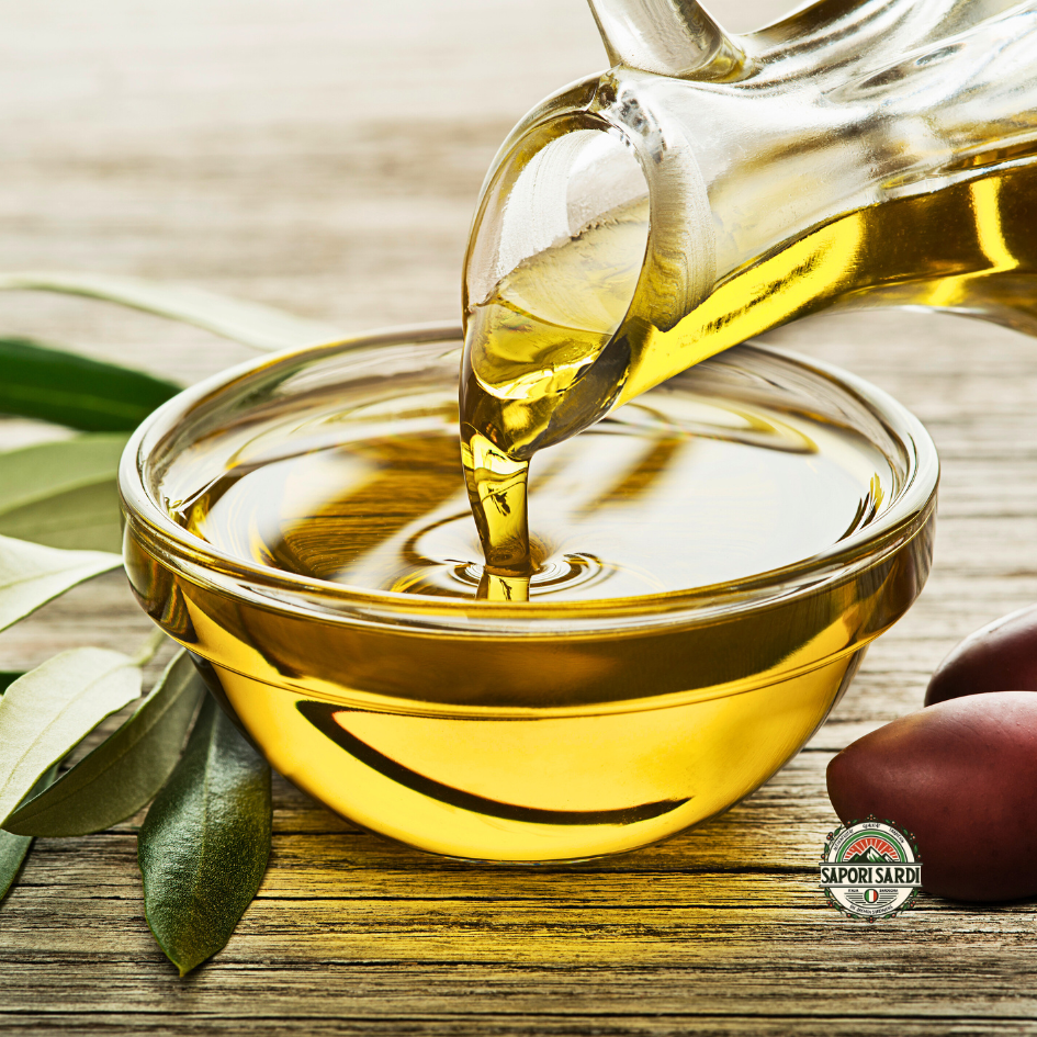 Extra Vergine Olivenöl in eine wird aus einem Krug in eine Glasschale gegossen.