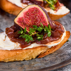 Feigen Senfsauce auf einem Brot mit Ricotta  und einer Feige. Dazu süße Zwiebeln.
