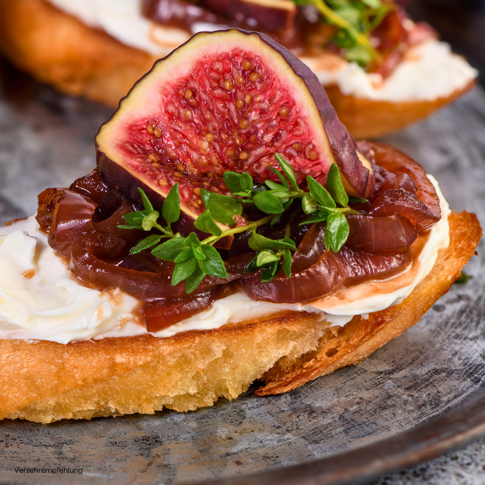 Feigen Senfsauce auf einem Brot mit Ricotta  und einer Feige. Dazu süße Zwiebeln.