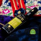 Flasche Olivenöl extra vergine Òzu von Pedralonga auf einem Tisch mit sardischer Kleidung.