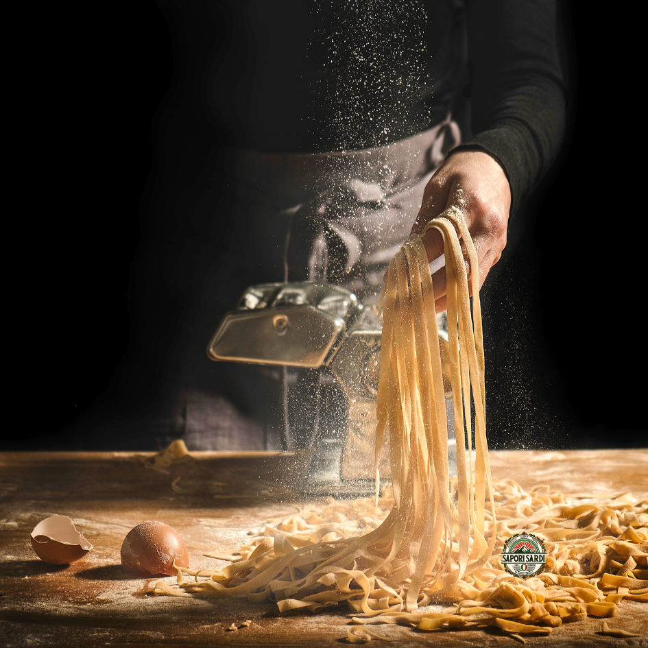 Frische handgemachte Pasta mit italienischem Pasta Mehl auf einem Holztisch.