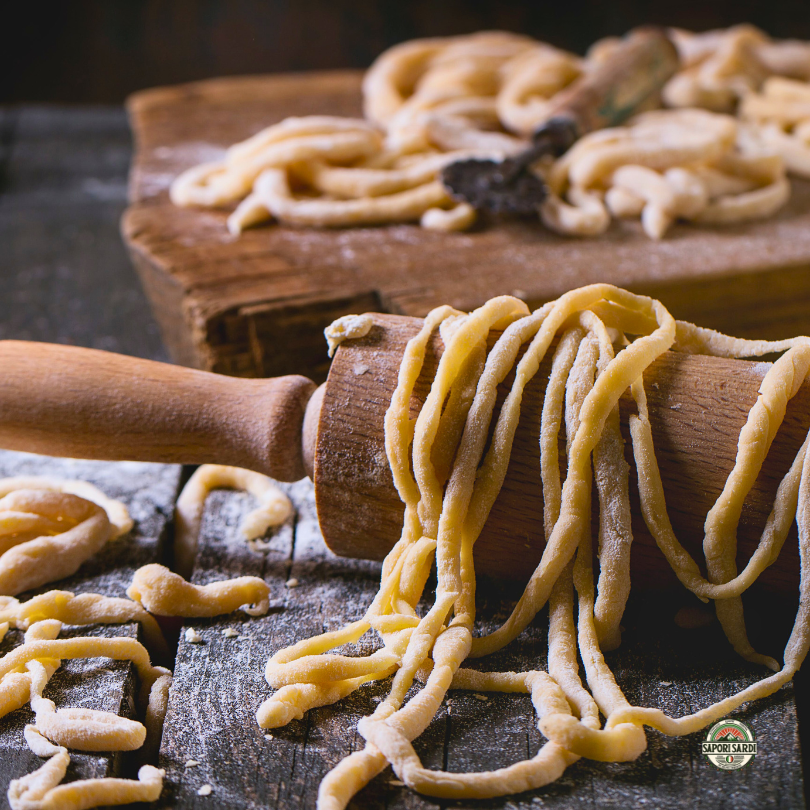 Pasta selbst gemacht. Nudelholz auf einem Holztisch mit frischer Pasta.