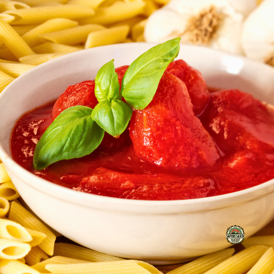 Geschälte Tomaten. Pelati mit Basilikum in einer Schale umgeben von Pasta.