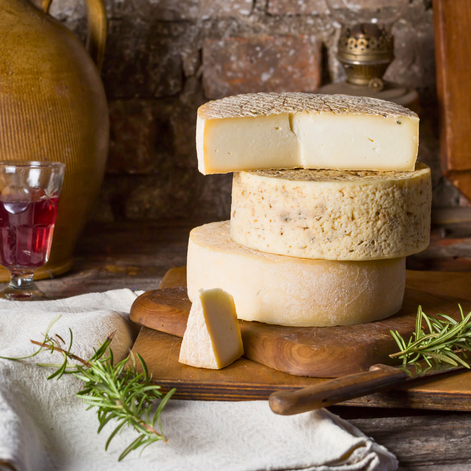 Ziegenkäse aus Sardinien gestapelt im ganzen Laib auf einem Holzbrett