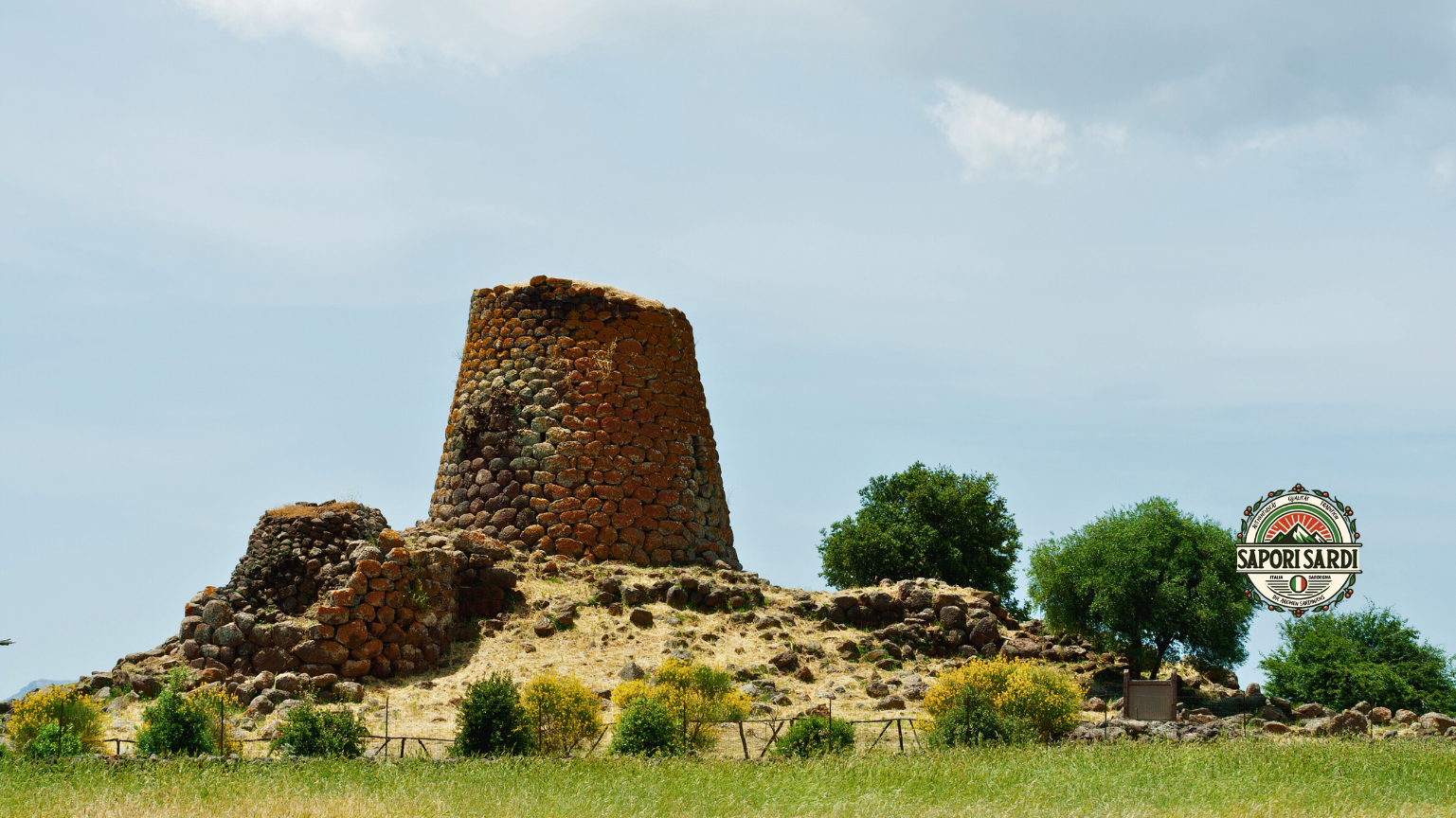 Eine Nuraghe auf Sardinien. Nuraghen sind alte einem Turm ähnliche Steinbauten auf Sardinien. Unten rechts im Bild ist das Logo von Sapori Sardi zu erkennen.